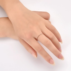 Macro detail of slim rose gold textured ring with delicate embossed gear patterns