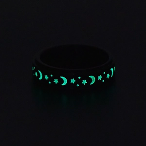 Glow-in-the-dark stainless steel ring featuring glowing moon and star patterns in the dark