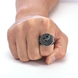 Detailed relief of an eagle emblem and engraved text on a vintage steel signet ring