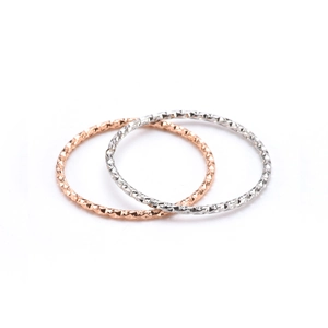 Minimalist geometric textured rings set in rose gold and silver finishes on white background