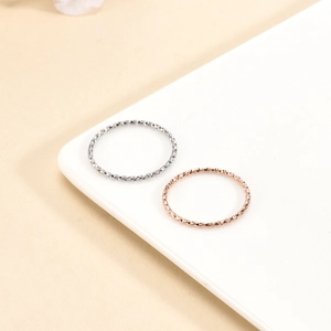 Macro shot of silver and rose gold thin rings with intricate textured diamond cutting