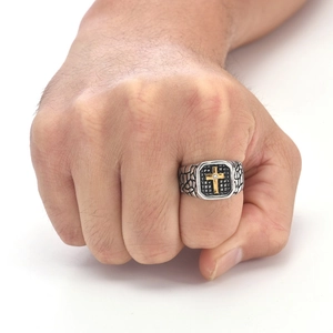 Close-up of vintage punk ring featuring a gold cross and rugged stone textures
