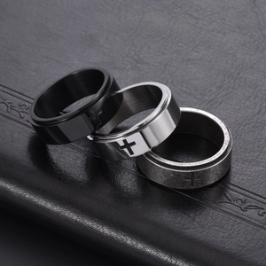 8mm spinner cross rings for men in black, silver, and vintage finish on leather background