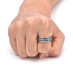 Close-up of vintage titanium steel ring with fleur-de-lis relief on a male model's hand