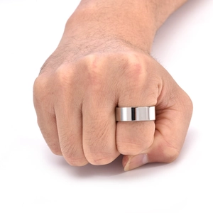 Close-up of wide polished silver stainless steel ring worn on a man's clenched fist