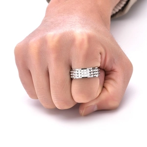 Macro shot of silver pyramid studded rotating ring on finger showing punk style detail