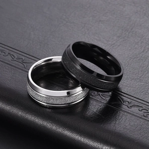 Detail of 8mm matte brushed titanium steel rings in black and silver on leather
