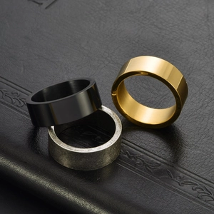 Three minimalist titanium steel rings in gold, black, and silver finishes on black leather