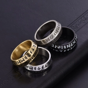 Makroaufnahme von vier nordischen Wikinger-Runenringen in Gold, Silber und Schwarz-Stahl
