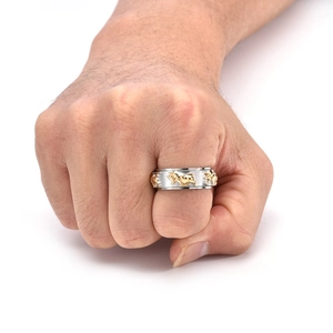 Detail of rotating bull head ring in titanium steel with two-tone gold and silver finish