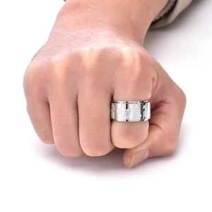 Vue macro d'une large bague en acier titane avec relief rotatif de créature mythique