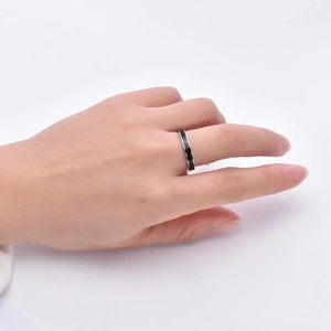 Detail of a 3mm black enamel stainless steel ring worn on finger in a lifestyle shot