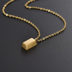Collier minimaliste avec pendentif barre plaqué or 18K sur fond noir mat chic
