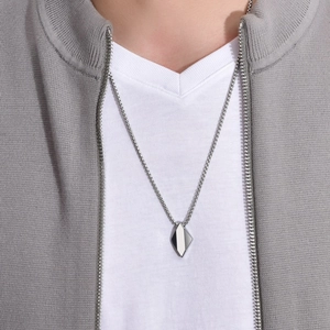 Détail d'un pendentif géométrique en tungstène avec finition bicolore argent et gris foncé
