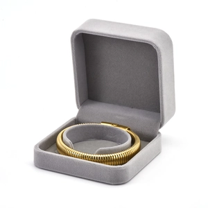 Polished gold circular chain bracelet displayed in a luxury gray velvet jewelry gift box