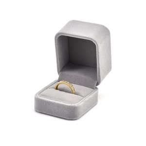 Close-up of golden pave ring with white crystals in a premium grey velvet box