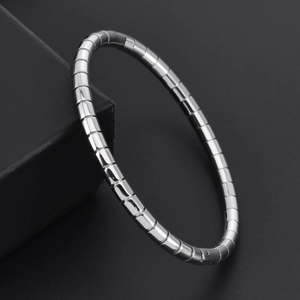 Polished silver 18K gold bamboo-style flexible steel bracelet on a premium jewelry box