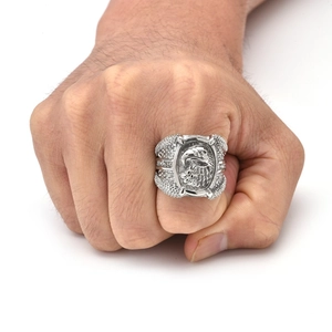 Vue détaillée d'une bague tête d'aigle argentée avec cristaux sur la main d'un homme