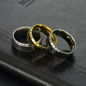 Close-up of three vintage Viking rune rings in silver, gold, and black stainless steel