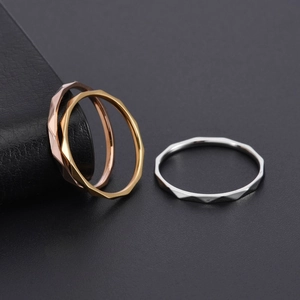 Detailed view of faceted geometric rings in gold, rose gold, and silver finishes