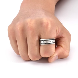 Detail of vintage silver Viking rune ring with twisted rope edges on male model hand