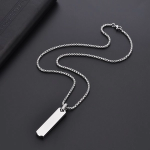 Close-up of polished stainless steel rectangular pendant on a silver box chain necklace