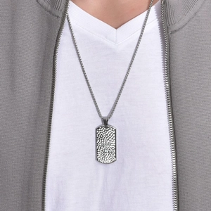 Gros plan du collier plaque militaire en acier titane avec texture martelée et croix
