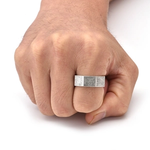 Macro shot of silver octagonal ring with brushed finish on male hand in a fist