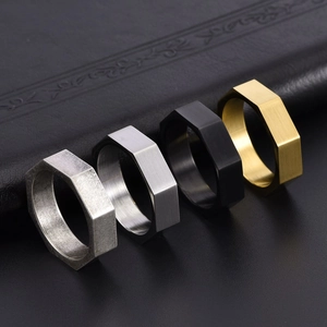 Close-up of octagonal geometric rings in brushed silver, gold, black and antique finishes
