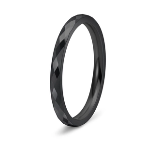 Macro shot of black tungsten ring featuring a faceted geometric surface and smooth inner edge