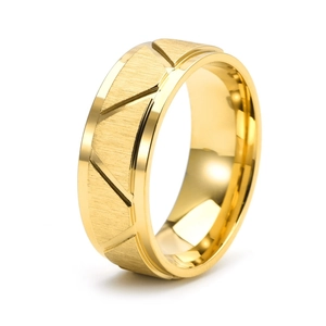 Macro shot of gold stainless steel ring with brushed finish and geometric engravings