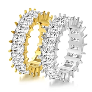 Eternity band rings with baguette cut diamonds in gold and silver finish on white background