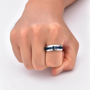 Dettaglio anello rotante in acciaio inossidabile con rune incise e catena blu stile vichingo