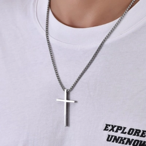 Gros plan du pendentif croix en titane avec gravure « I CAN DO ALL THINGS » sur chaîne box