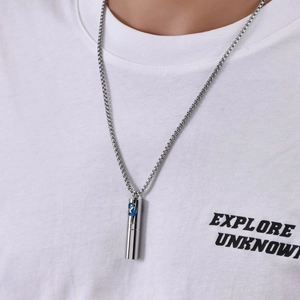 Detail eines zylindrischen Edelstahlanhängers mit blauem Zirkon an einer Box-Kette