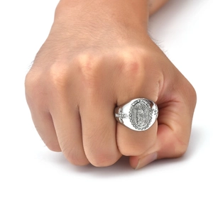 Dettaglio macro di anello a sigillo Vergine Maria in argento con incisione a croce laterale