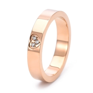 Detail view of 18K rose gold heart ring featuring three sparkling inset diamonds