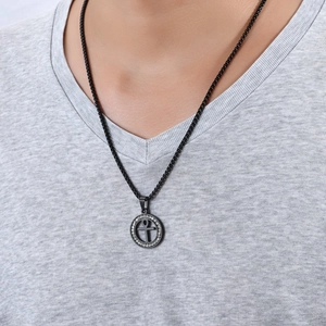 Gros plan d'un pendentif croix Ankh noir serti de strass porté par un mannequin