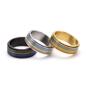 Detailed shot of black, silver, and gold stainless steel rings with rainbow stripe bands