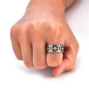 Detailed view of vintage punk ring with golden cross relief on embossed metal surface
