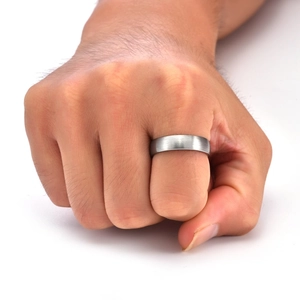 Close-up of matte brushed silver tungsten ring on male hand with focus on texture