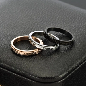 Three 3mm hammered spinner rings in rose gold, silver, and black on a black leather box