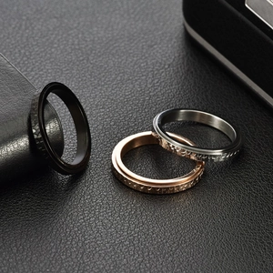 Hammered spinning rings in black, rose gold, and silver on black leather surface