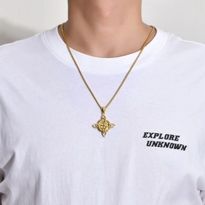Close-up of gold Viking Celtic Knot necklace on white shirt showing detailed craftsmanship