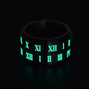 Macro shot of black titanium spinner ring with luminous Roman numerals glowing in the dark