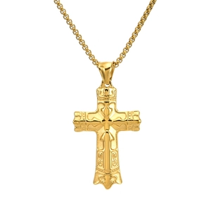 Close-up of golden cross pendant with relief texture on a metallic link chain