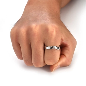 Makro-Detail eines silbernen Wellenrings mit poliertem Finish am Finger