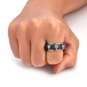 Close-up of vintage stainless steel tiger head spinner ring on male hand with punk design