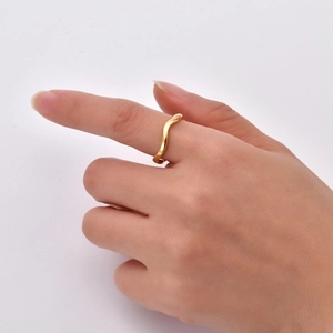Nahaufnahme eines minimalistischen wellenförmigen Rings aus 18K vergoldetem Edelstahl