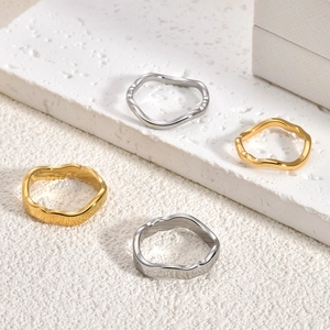 Unregelmäßige Wellenmuster-Ringe aus 18K Gold und Silber Edelstahl auf Steinfläche